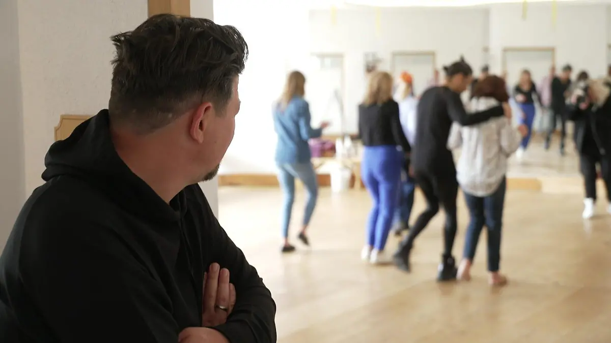 Starkoch Tim Mälzer steht am Eingang zum Kursraum, in dem Let's Dance-Juror und Choreograph Jorge González gerade einen Salsa-Kurs gibt.