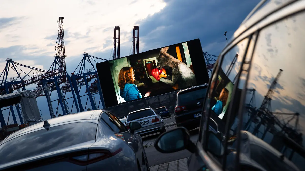 03.06.2020, Hamburg: Autos stehen auf der Autokino und Auto-Konzertfläche "Cruise Inn" am Kreuzfahrtterminal in Hamburg-Steinwerder während der Film "Die Känguru-Chroniken" läuft . Das Kino hat am Mittwochabend mit seiner ersten Vorstellung die Autokino-Saison in der Hansestadt eingeläutet. Vor der 220 Quadratmeter großen Leinwand sollen bis zu 620 Autos Platz finden. Foto: Christian Charisius/dpa +++ dpa-Bildfunk +++