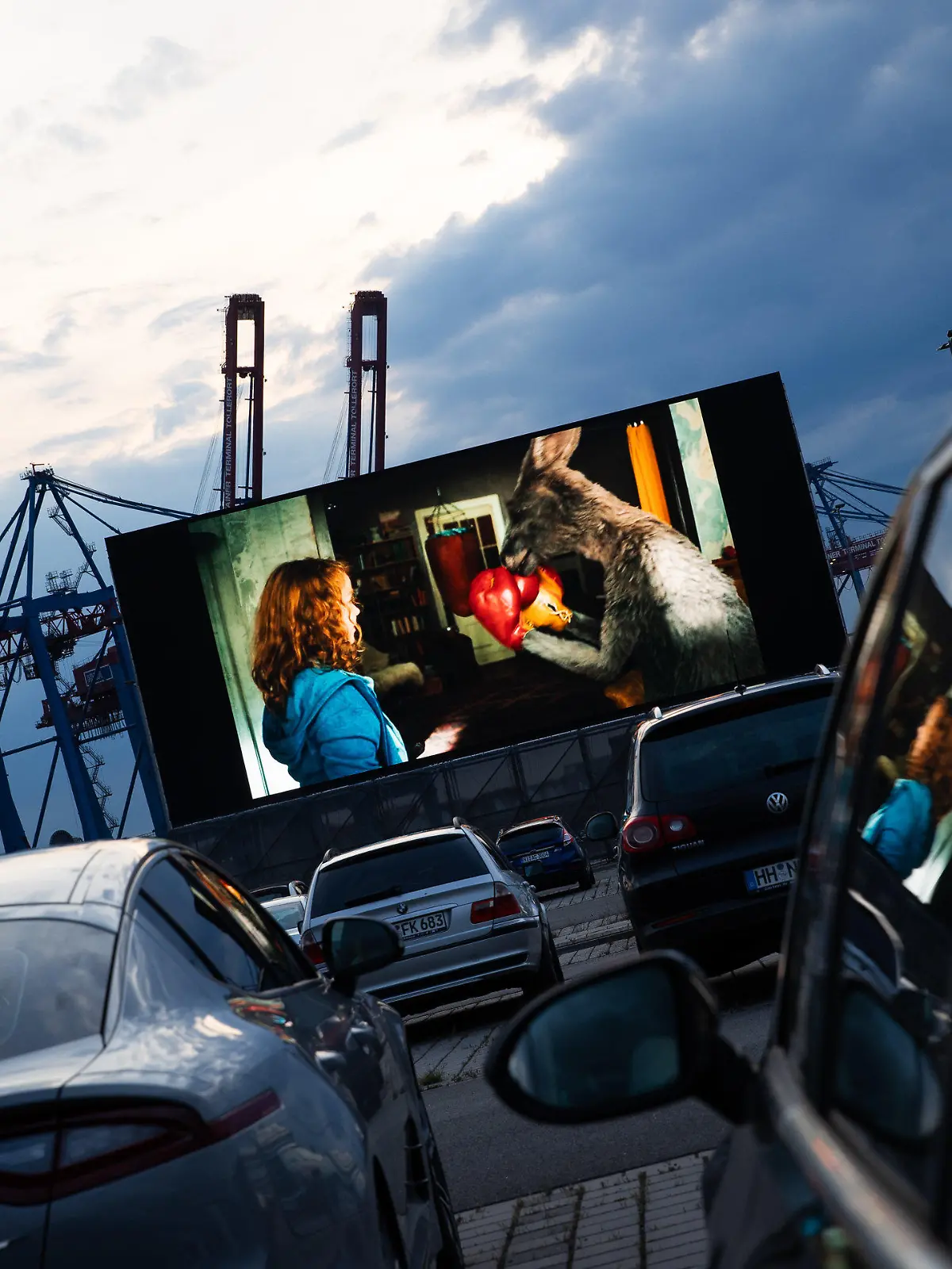 03.06.2020, Hamburg: Autos stehen auf der Autokino und Auto-Konzertfläche "Cruise Inn" am Kreuzfahrtterminal in Hamburg-Steinwerder während der Film "Die Känguru-Chroniken" läuft . Das Kino hat am Mittwochabend mit seiner ersten Vorstellung die Autokino-Saison in der Hansestadt eingeläutet. Vor der 220 Quadratmeter großen Leinwand sollen bis zu 620 Autos Platz finden. Foto: Christian Charisius/dpa +++ dpa-Bildfunk +++