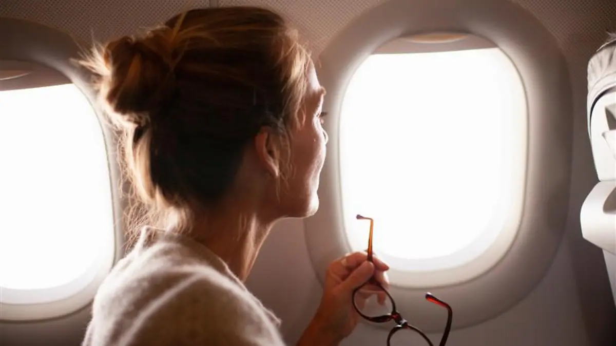 Frau schaut aus dem Flugzeug.