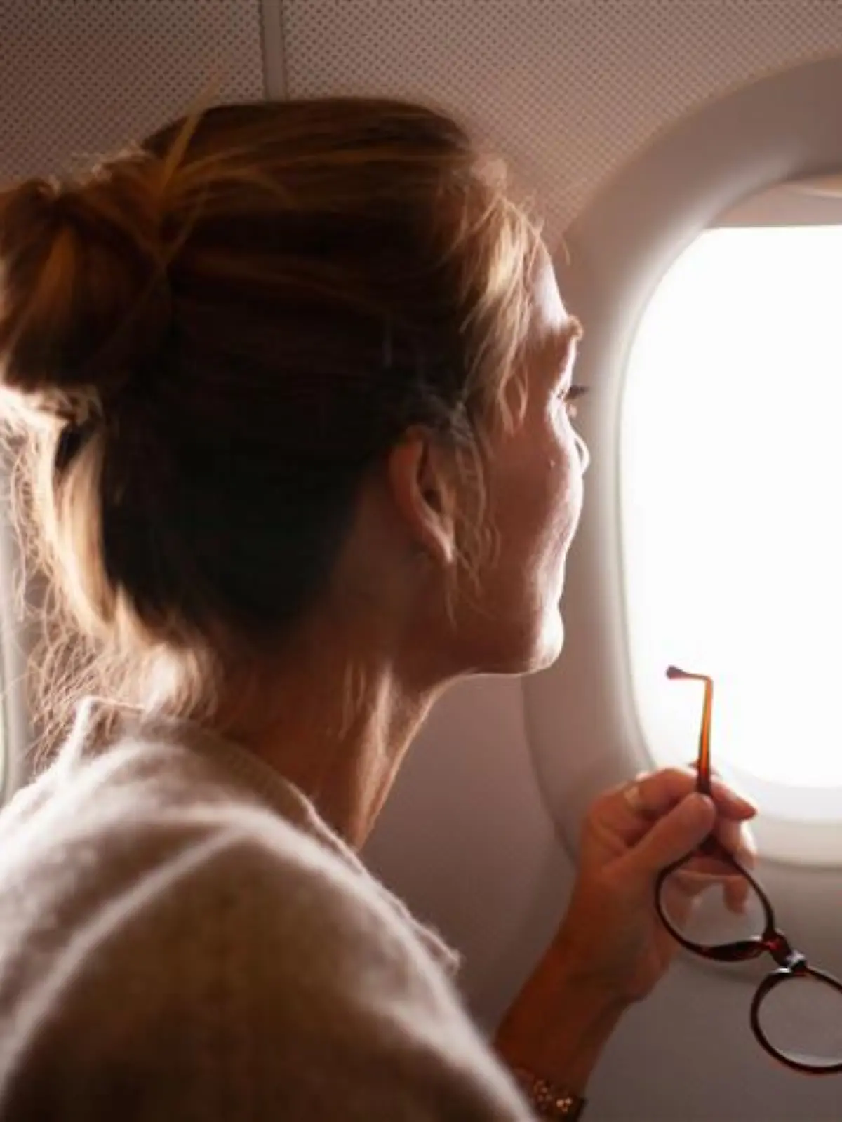 Frau schaut aus dem Flugzeug.