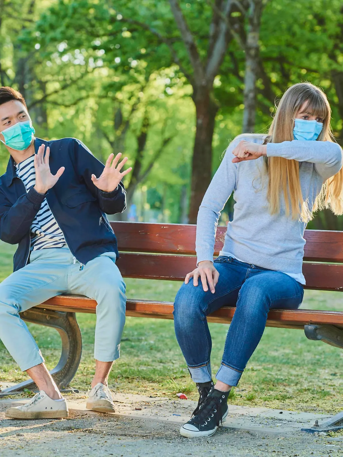 Frau mit Maske niest auf Bank