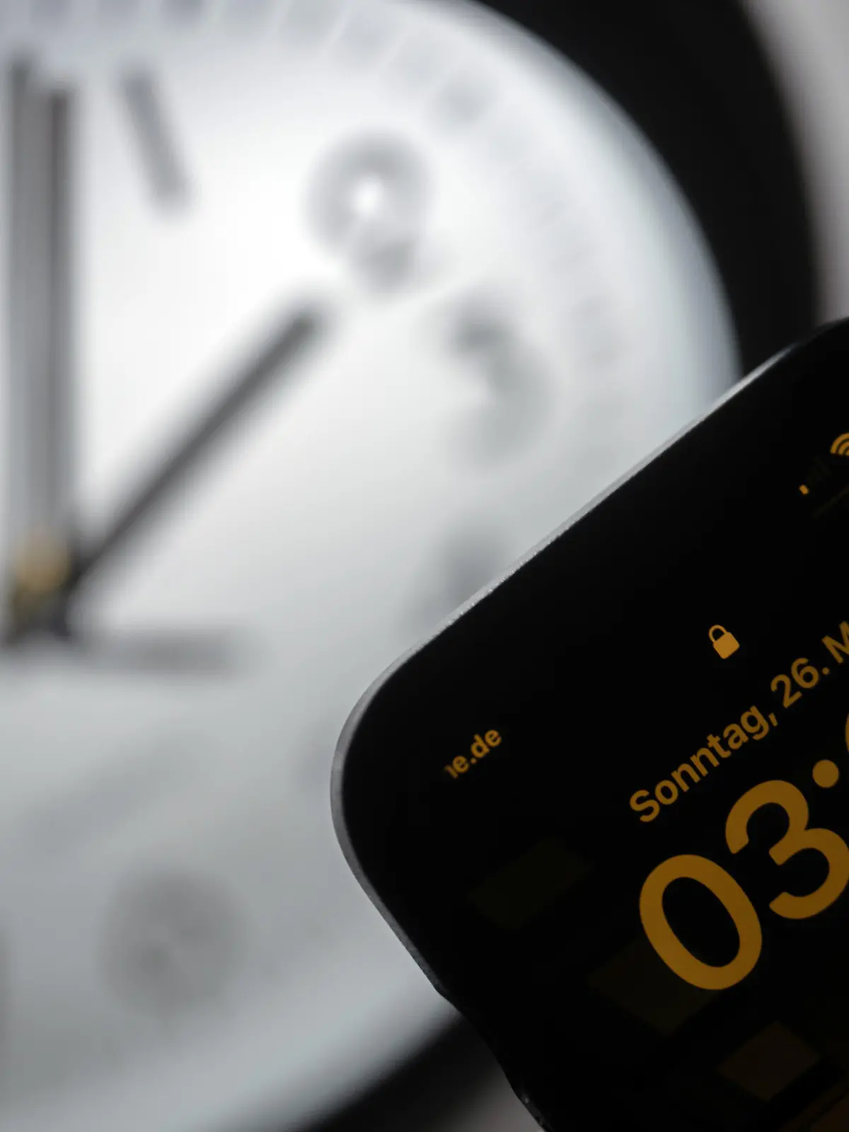 PRODUKTION - 21.03.2023, Hessen, Gießen: Ein Smartphone zeigt die Uhrzeit «03:03» an, während auf einer analogen Uhr noch 02:03 Uhr ist. Am 26. März werden die Uhren um 02:00 Uhr auf 03:00 Uhr vorgestellt und die Sommerzeit beginnt. (zu dpa: Adieu Analoguhr? Wie Zeigeruhren weniger werden) Foto: Sebastian Christoph Gollnow/dpa +++ dpa-Bildfunk +++