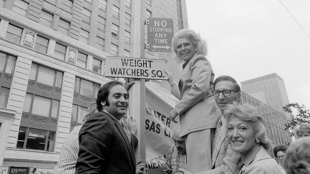 Bild aus besseren Zeiten: WeightWatchers-Gründerin Jean Nidetch hält am 11. Juni 1973 ein Schild mit der Aufschrift „Weight Watchers Sq.” am Times Square in New York City in die Luft. 