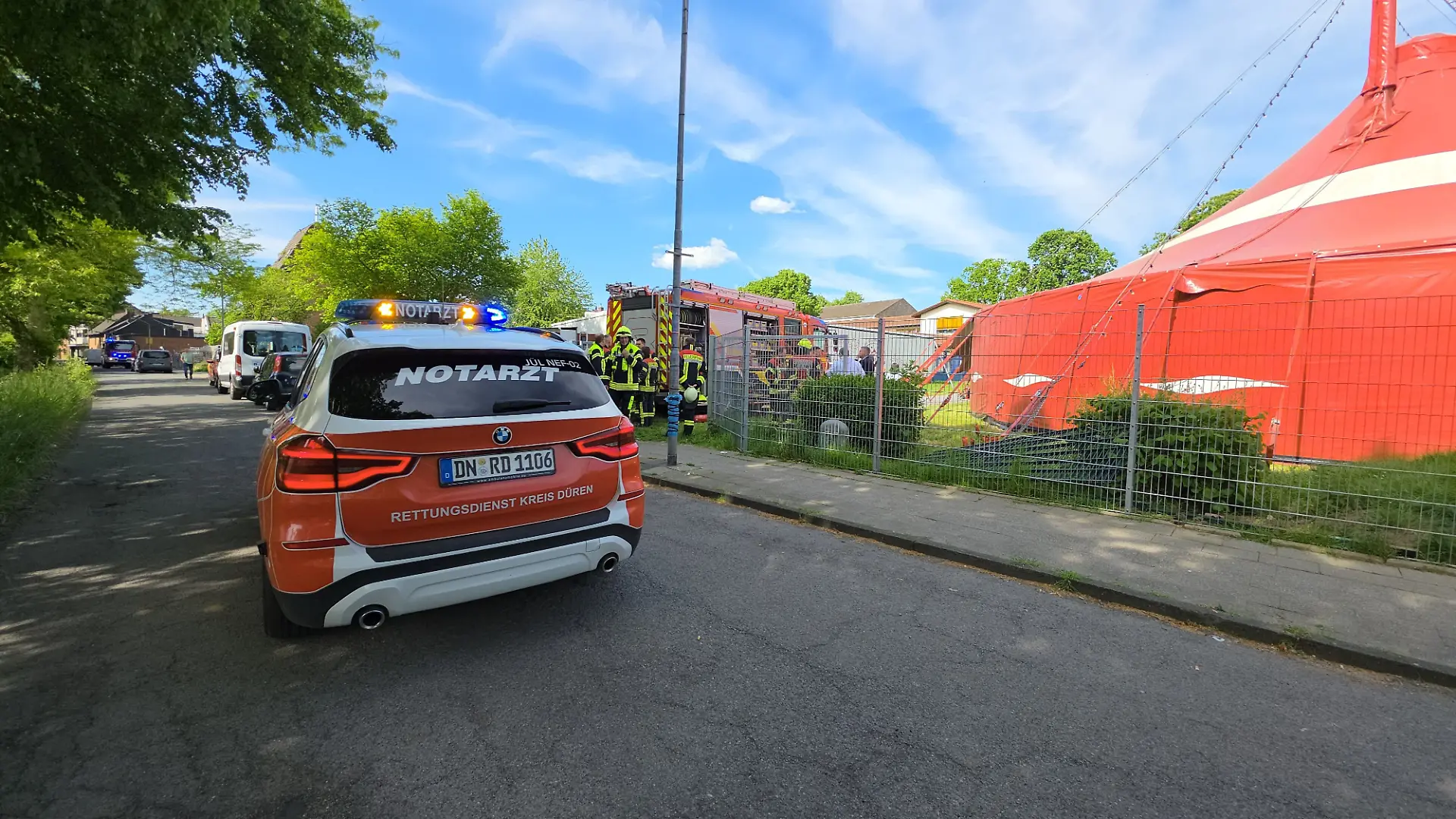 Ein Notarztfahrzeug steht vor einem Zirkuszelt. Beim Brand eines Zirkuszeltes im Kreis Düren sind 17 Kinder und drei Erwachsene verletzt worden.
