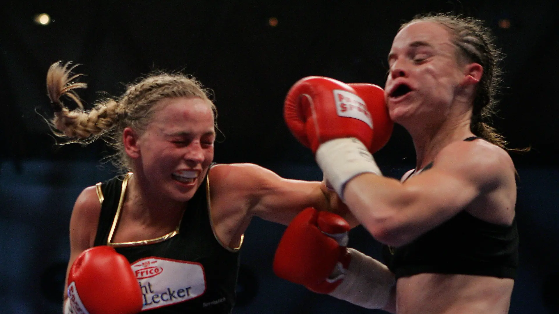 KARLSRUHE, GERMANY - NOVEMBER 30: Regina Halmich of Germany (L) lands a punch against Hagar Shmoulefeld Finer of Israel during their WIBF World Championship flyweight title fight at the DM Arena on November 30, 2007 in Karlsruhe, Germany. Halmich, who won the fight, has said she will retire after 13 years of professional boxing and 12 years as the unbeaten world champion. (Photo by Vladimir Rys/Bongarts/Getty Images)
