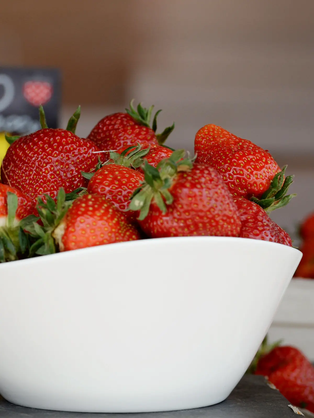 Eine Schale mit Erdbeeren steht am 20.05.2015 in Gestorf (Niedersachsen)vor einem Schild mit einer Aufschrift auf einem Verkaufstisch. Niedersachsen ist mit mehr als 4.200 Hektar Anbaufläche Erdbeerland Nummer eins in Deutschland. Foto: Susann Prautsch/dpa (zu lni "Erdbeersaison startet - Erzeuger müssen mehr für Erntehelfer zahlen" vom 27.05.2015) +++(c) dpa - Bildfunk+++