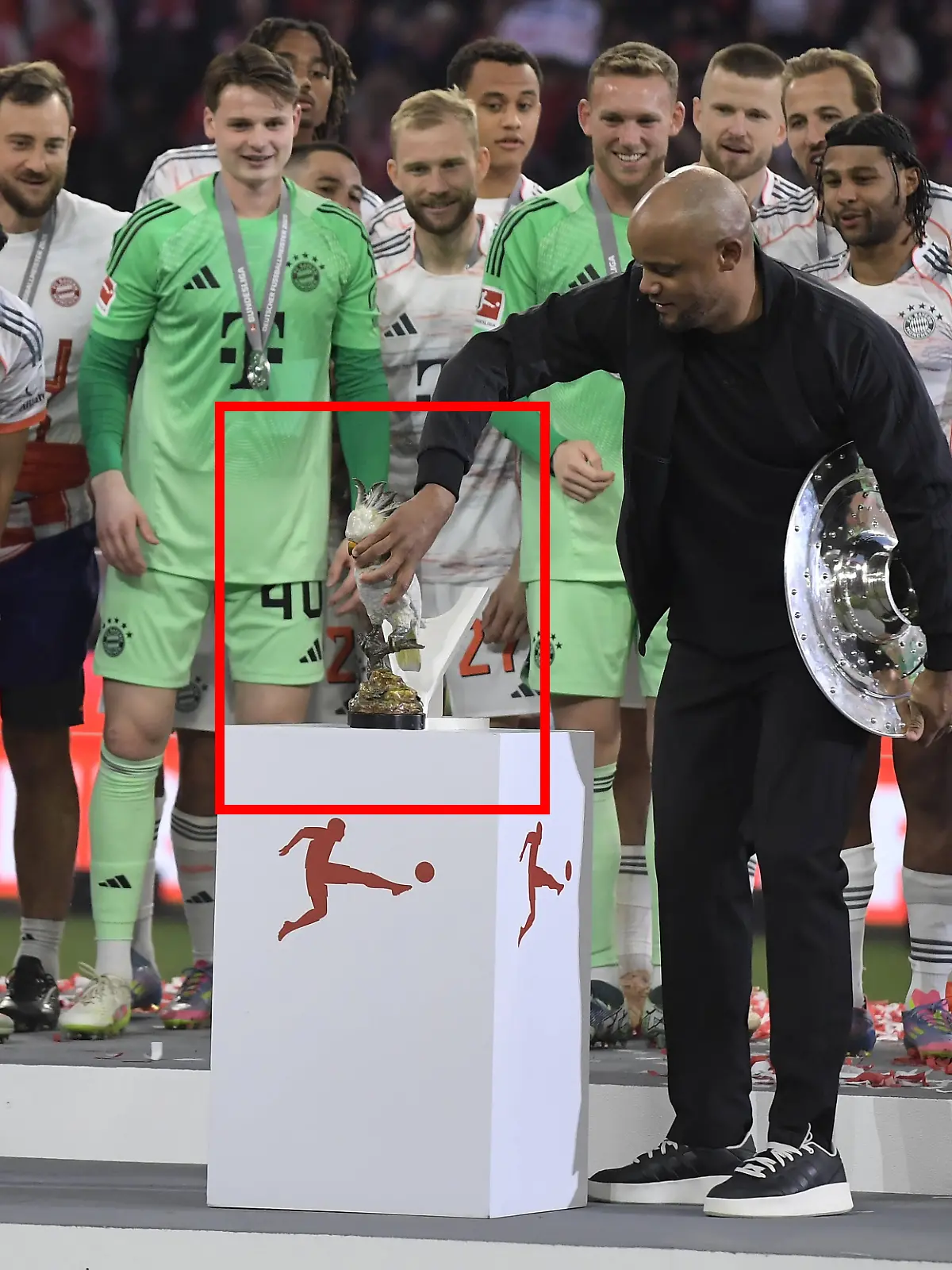 Vincent Kompany platziert einen silbernen Kakadu auf dem Sockel.