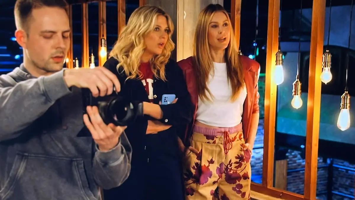 GZSZ-Jessica steht mit anderen Darstellern in farbenfrohem Outfit zusammen.