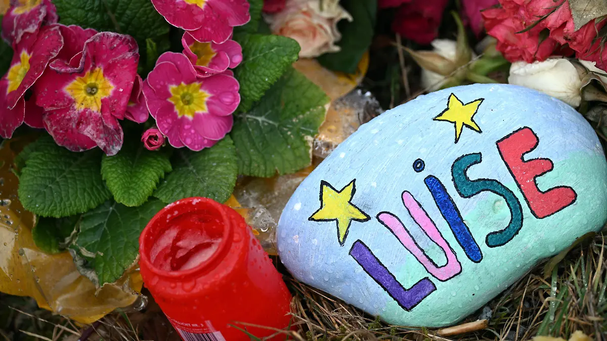22.03.2023, Nordrhein-Westfalen, Freudenberg: Blumen, Kerzen und ein bunt bemalter und mit "Luise" beschriebener Stein liegen am Tatort. Mit einer Trauerfeier nehmen Angehörige der getöteten zwölfjährigen Luise aus Freudenberg im Siegerland Abschied von dem Mädchen. Der gewaltsame Tod der Zwölfjährigen am 11. März hat viele Menschen geschockt. Zwei 12 und 13 Jahre alte Mädchen hatten gestanden, Luise mit Messerstichen getötet zu haben. Foto: Federico Gambarini/dpa +++ dpa-Bildfunk +++