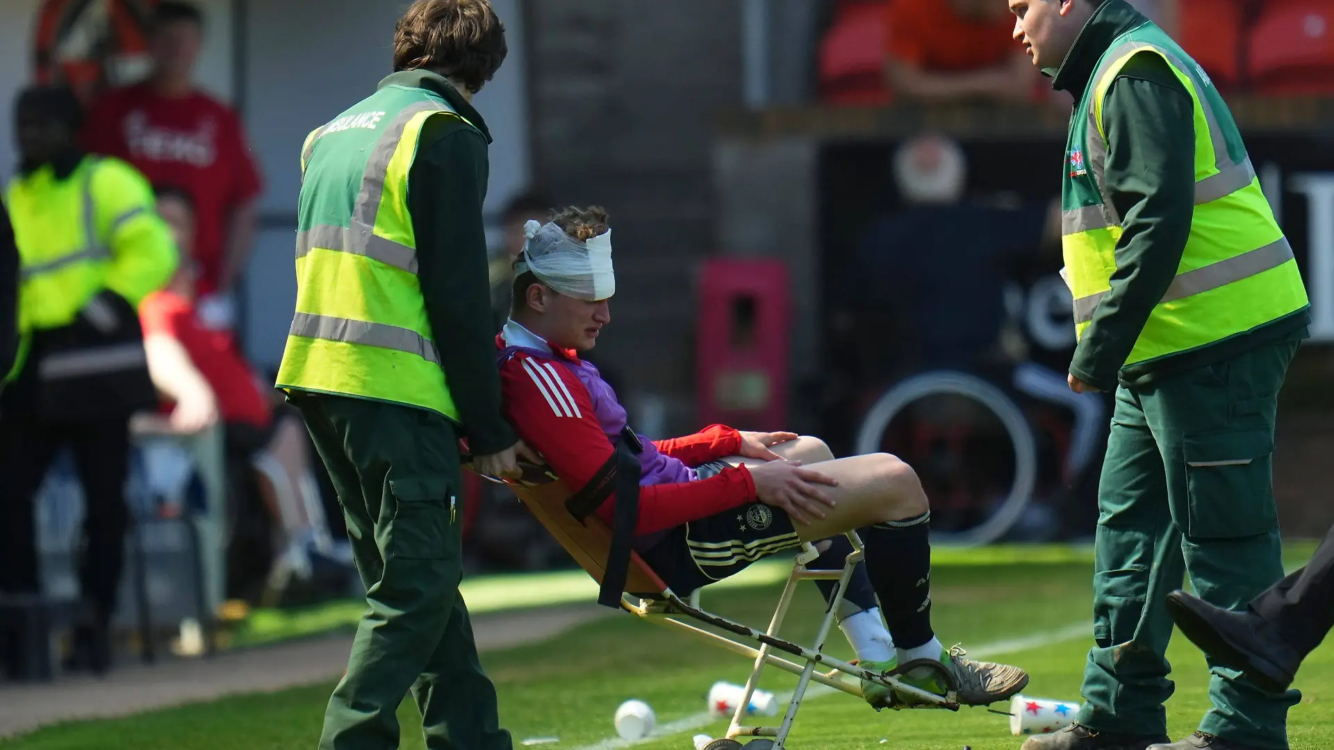 Aberdeens Jack MacKenzie wird nach dem Spiel zwischen Dundee und Aberdeen von Sanitätern behandelt. Zuvor wurde er von einer Sitzschale getroffen, die ein Anhänger geworfen hatte.