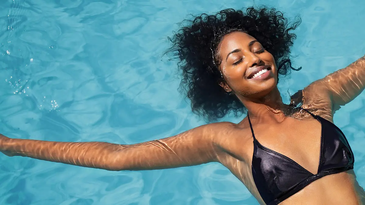 Pool kaufen: Frau liegt glücklich im Wasser.
