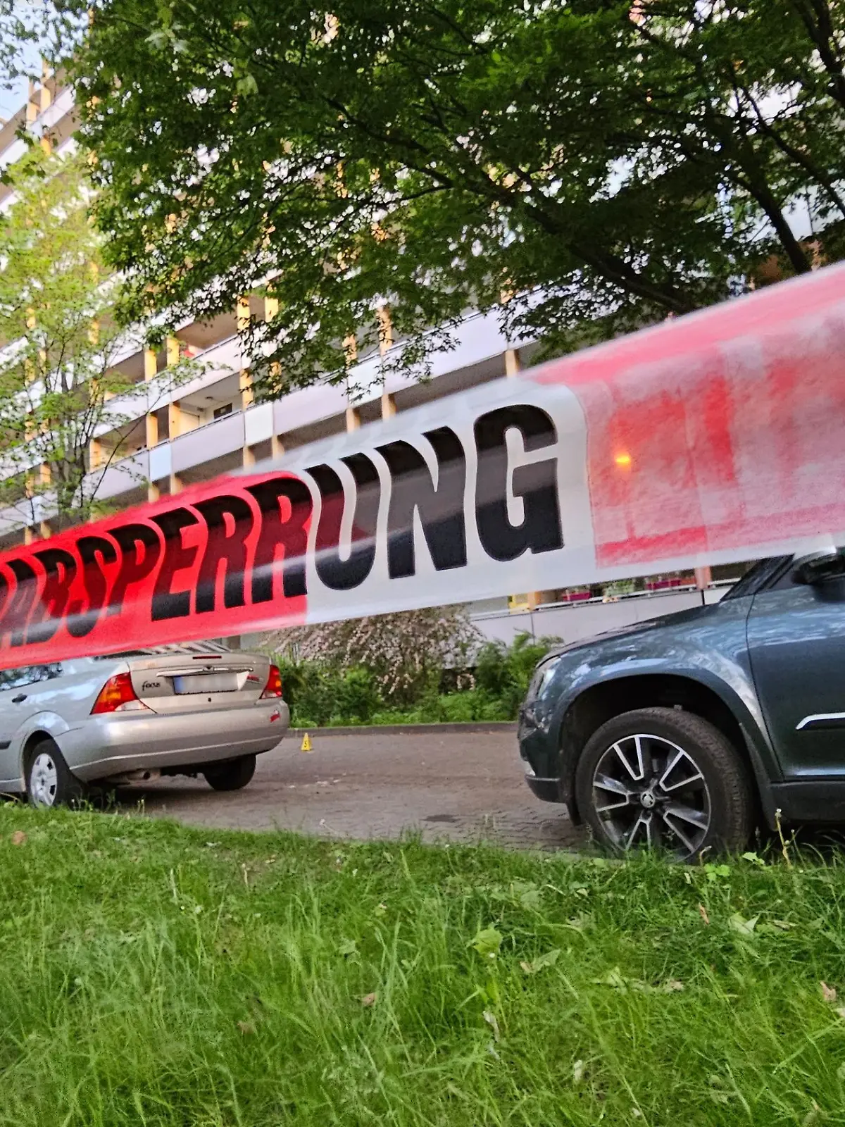 Halle: Ein Absperrband der Polizei ist am Tatort angebracht. Bei einem Angriff vor einem Mehrfamilienhaus in Halle/Saale in Sachsen-Anhalt sind drei Menschen verletzt worden, darunter eine Zwölfjährige.