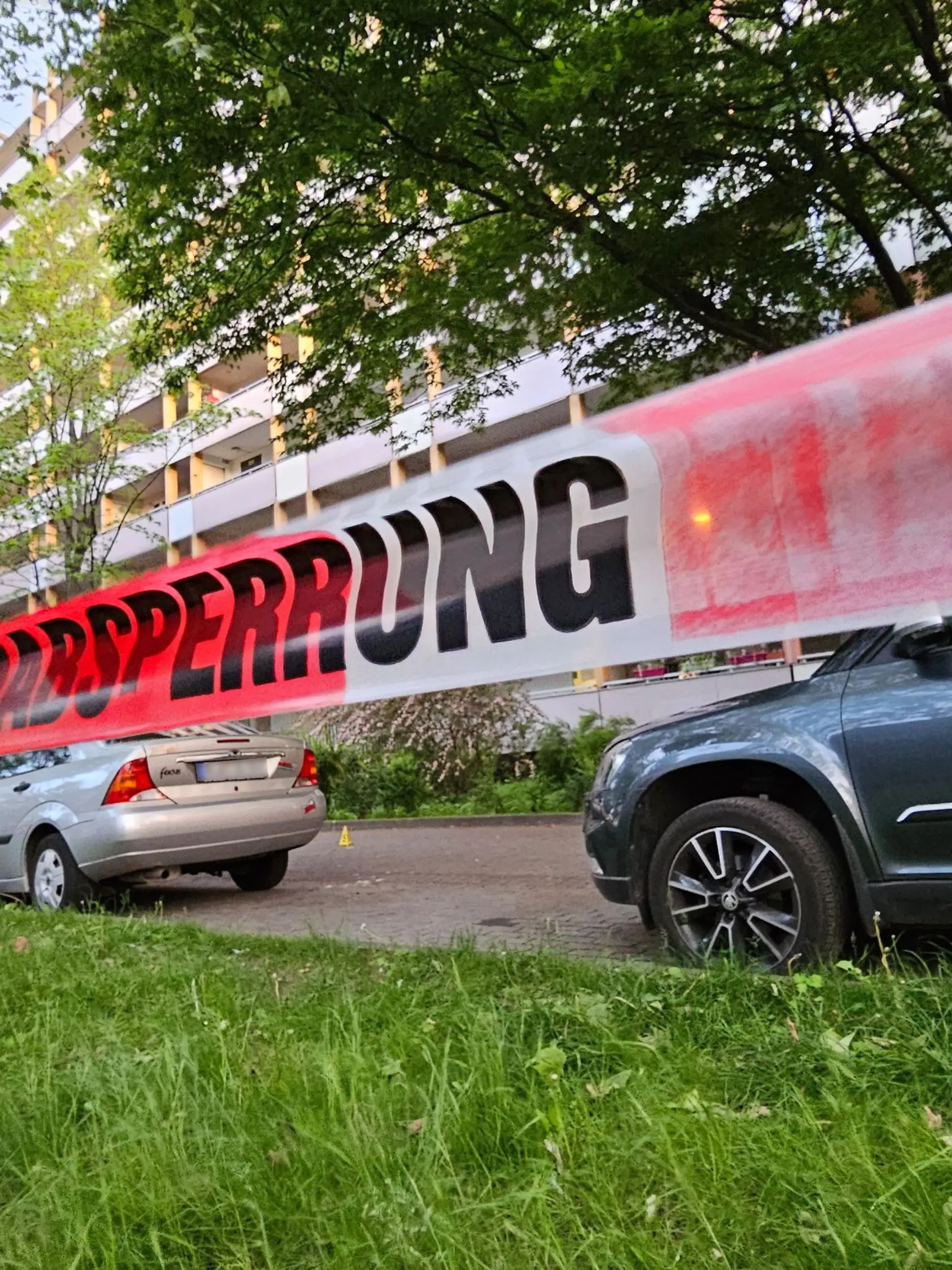 Halle: Ein Absperrband der Polizei ist am Tatort angebracht. Bei einem Angriff vor einem Mehrfamilienhaus in Halle/Saale in Sachsen-Anhalt sind drei Menschen verletzt worden, darunter eine Zwölfjährige.