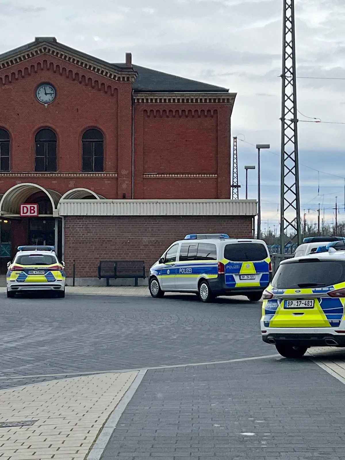 24.03.2023, Brandenburg, Guben: Polizeifahrzeuge stehen vor dem Bahnhof in Guben. Ein 37 Jahre alter Mann hat am Freitagnachmittag in einem Regionalzug von Cottbus nach Frankfurt (Oder) Fahrgäste bedroht und eine Jugendliche mit einem axtähnlichen Gegenstand verletzt. Das berichtete ein Sprecher der Polizeidirektion Süd. Die Polizei habe den Zug am Bahnhof in Guben (Kreis Spree-Neiße) gestoppt und den Verdächtigen, der polnischer Staatsbürger sei, festgenommen. Foto: Ute Richter/dpa +++ dpa-Bildfunk +++
