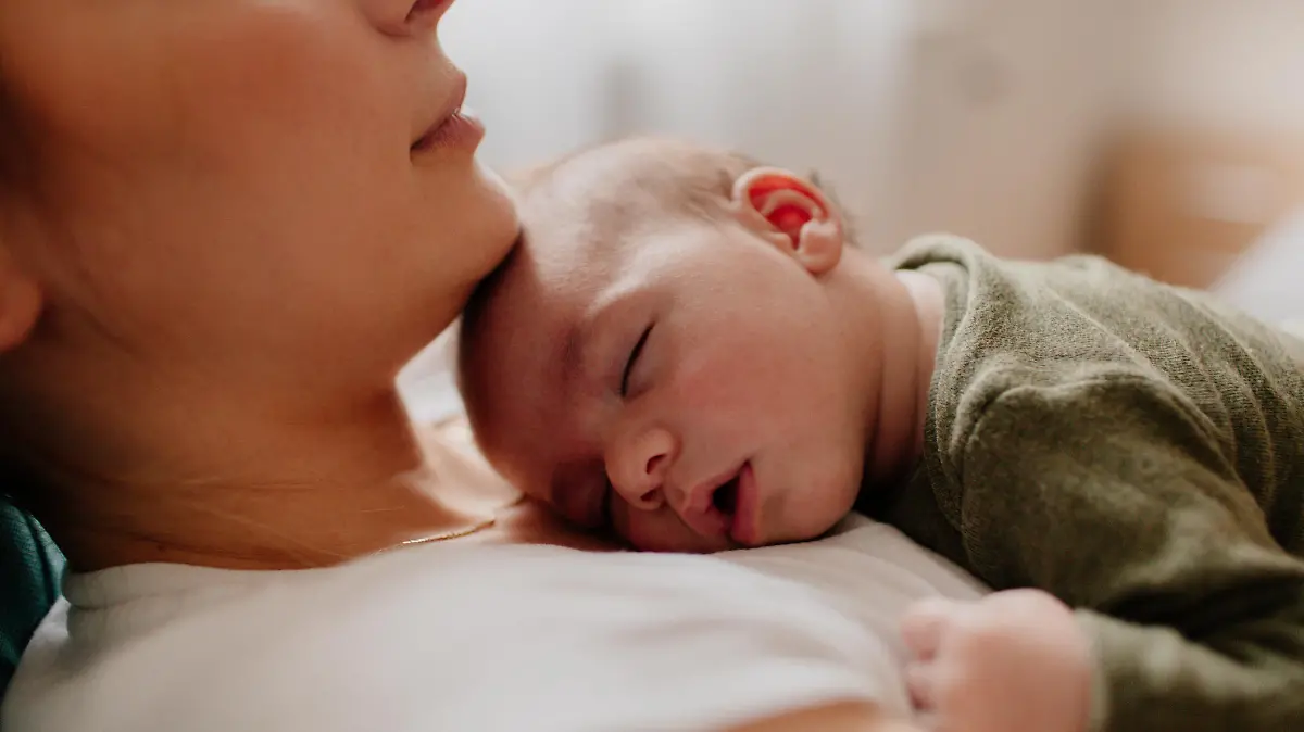 Baby schläft auf dem Bauch der Mutter
