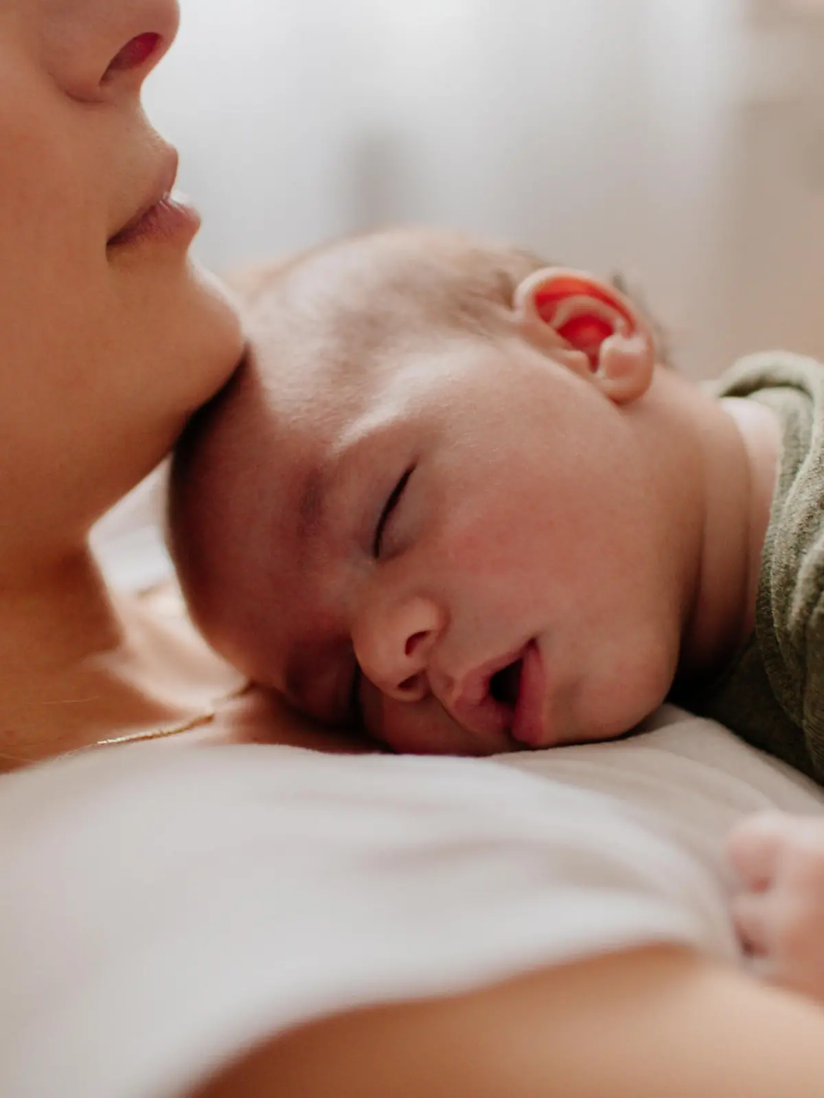 Baby schläft auf dem Bauch der Mutter