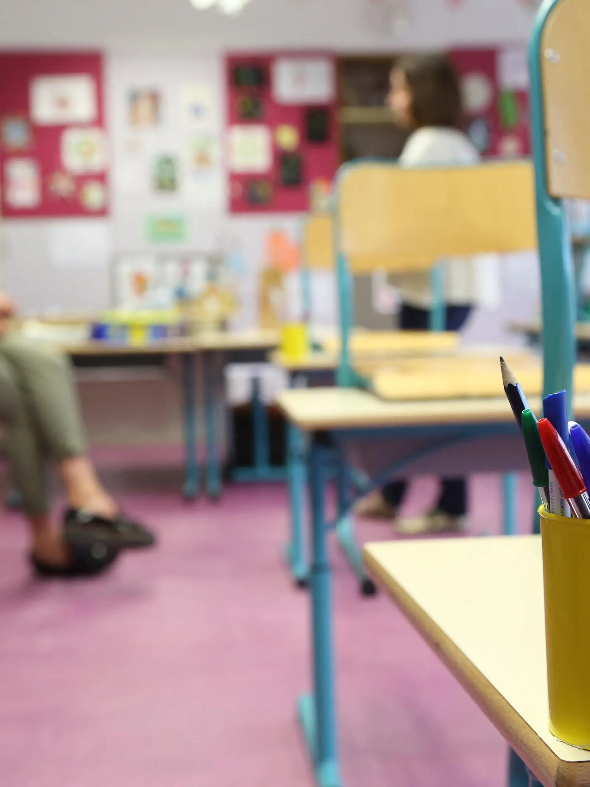 Lehrerin sitzt in leerem Klassenzimmer