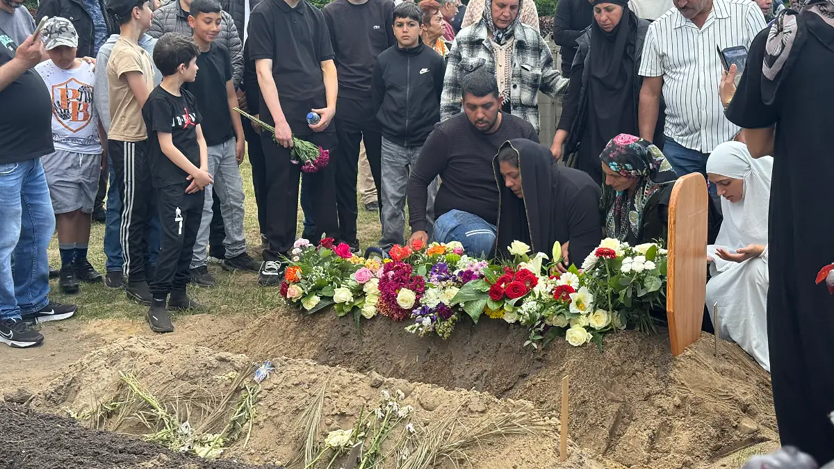 Tolgas Mutter kniet weinend am Grab ihres getöteten Sohnes. 