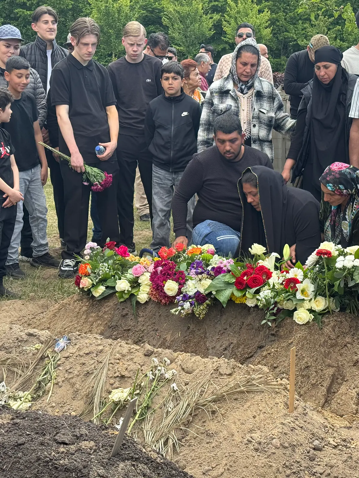Tolgas Mutter kniet weinend am Grab ihres getöteten Sohnes. 