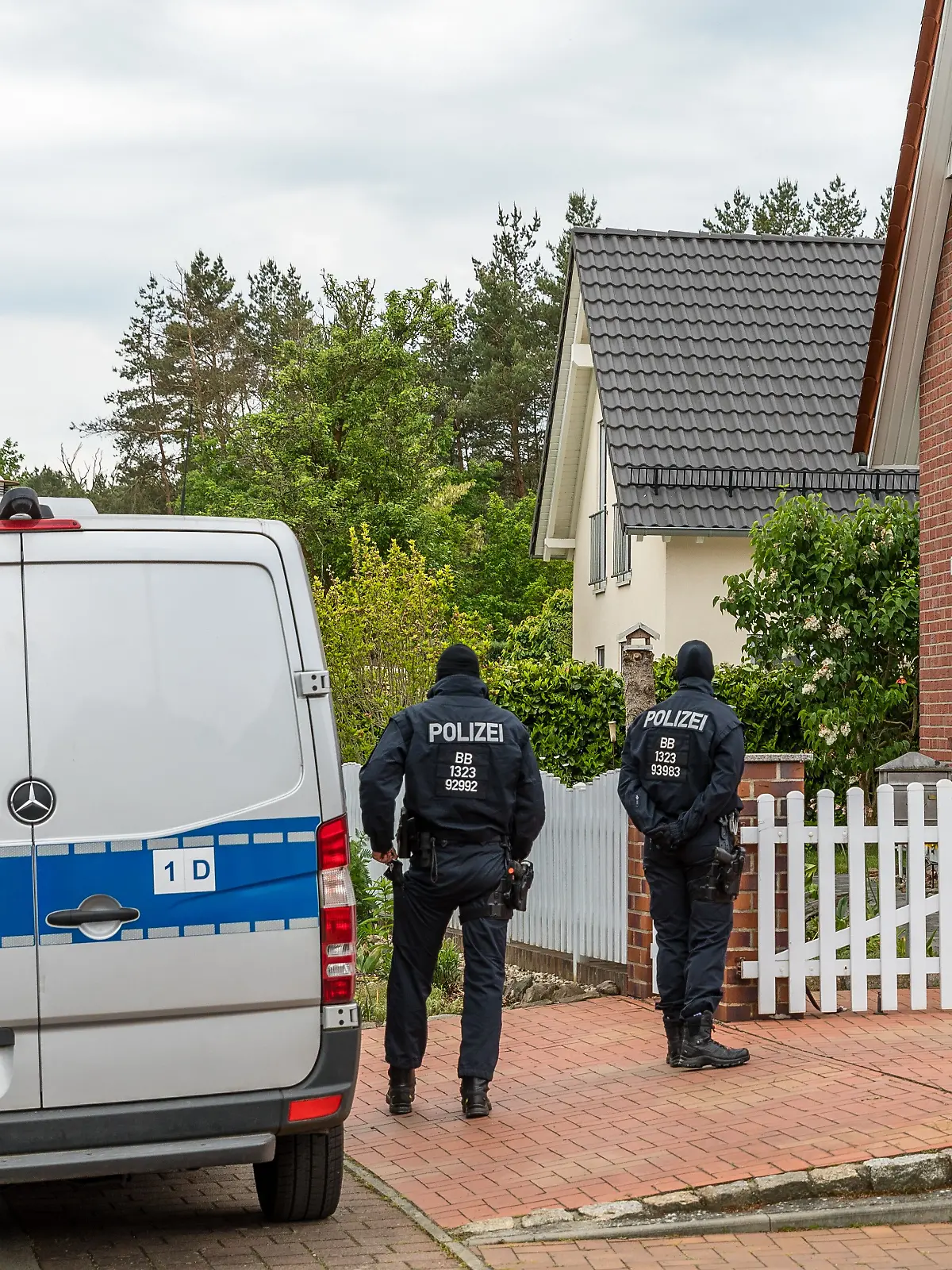 21.05.2025, Brandenburg, Altdöbern: Polizisten durchsuchen ein Haus in Altdöbern. Der Generalbundesanwalt geht gegen junge Männer vor, die einer mutmaßlichen rechtsextremen Terrorzelle angehören sollen. Bei einer Polizei-Aktion gegen eine Vereinigung, die sich selbst «Letzte Verteidigungswelle» nennt, werden am frühen Morgen in Brandenburg, Mecklenburg-Vorpommern und Hessen fünf Verdächtige festgenommen. Sie sollen nach Angaben der Karlsruher Behörde 14 bis 18 Jahre alt sein. Foto: Frank Hammerschmidt/dpa +++ dpa-Bildfunk +++