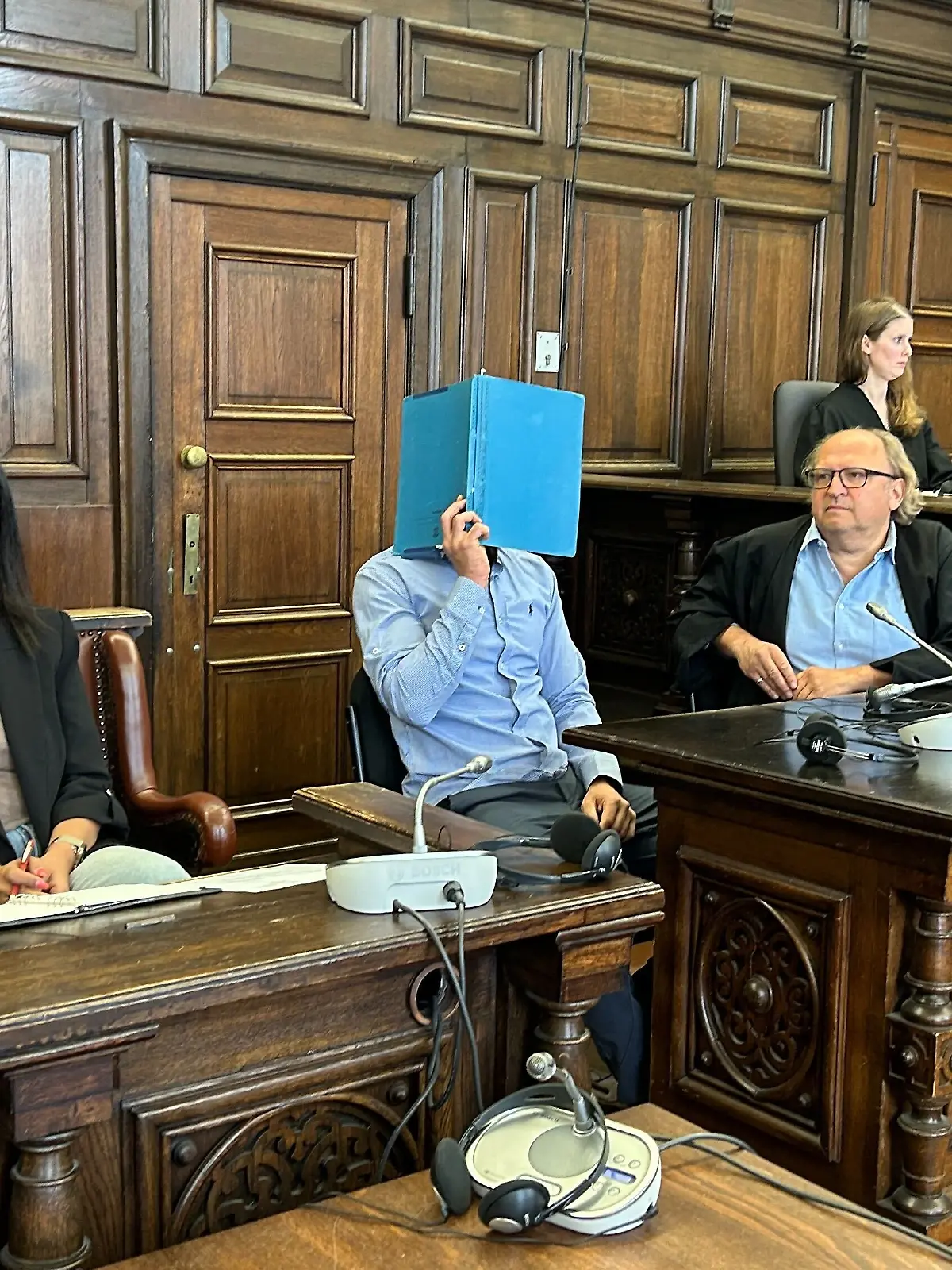 Der Angeklagte Anouar B. versteckt beim Prozess in Hamburg sein Gesicht hinter einer Mappe. 