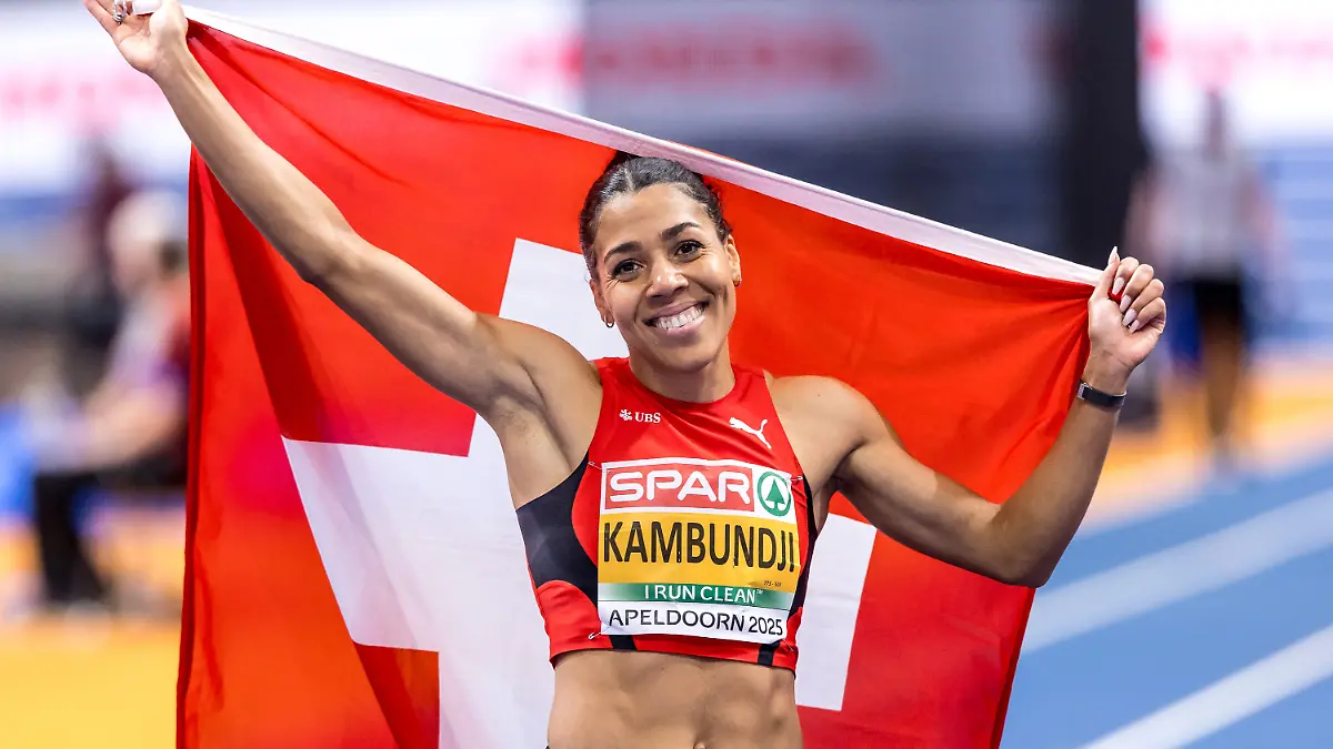 Die Schweizer Sprinterin Mujinga Kambundji posiert nach dem Finale über 60m in Apeldoorn mit ihrer Flagge.