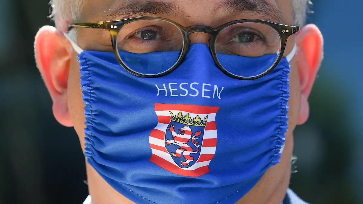 27.05.2020, Hessen, Wiesbaden: Tarek Al-Wazir (Bündnis 90/Die Grünen), Wirtschaftsminister des Landes Hessen, trägt beim Aktionstag privater Busunternehmen in Wiesbaden einen Mundschutz mit der Aufschrift und dem Wappen von Hessen. Die Busunternehmer fordern Soforthilfen wegen der Corona-Krise. Rund 100 Busse aus ganz Hessen nahmen an der Veranstaltung teil. Foto: Arne Dedert/dpa +++ dpa-Bildfunk +++