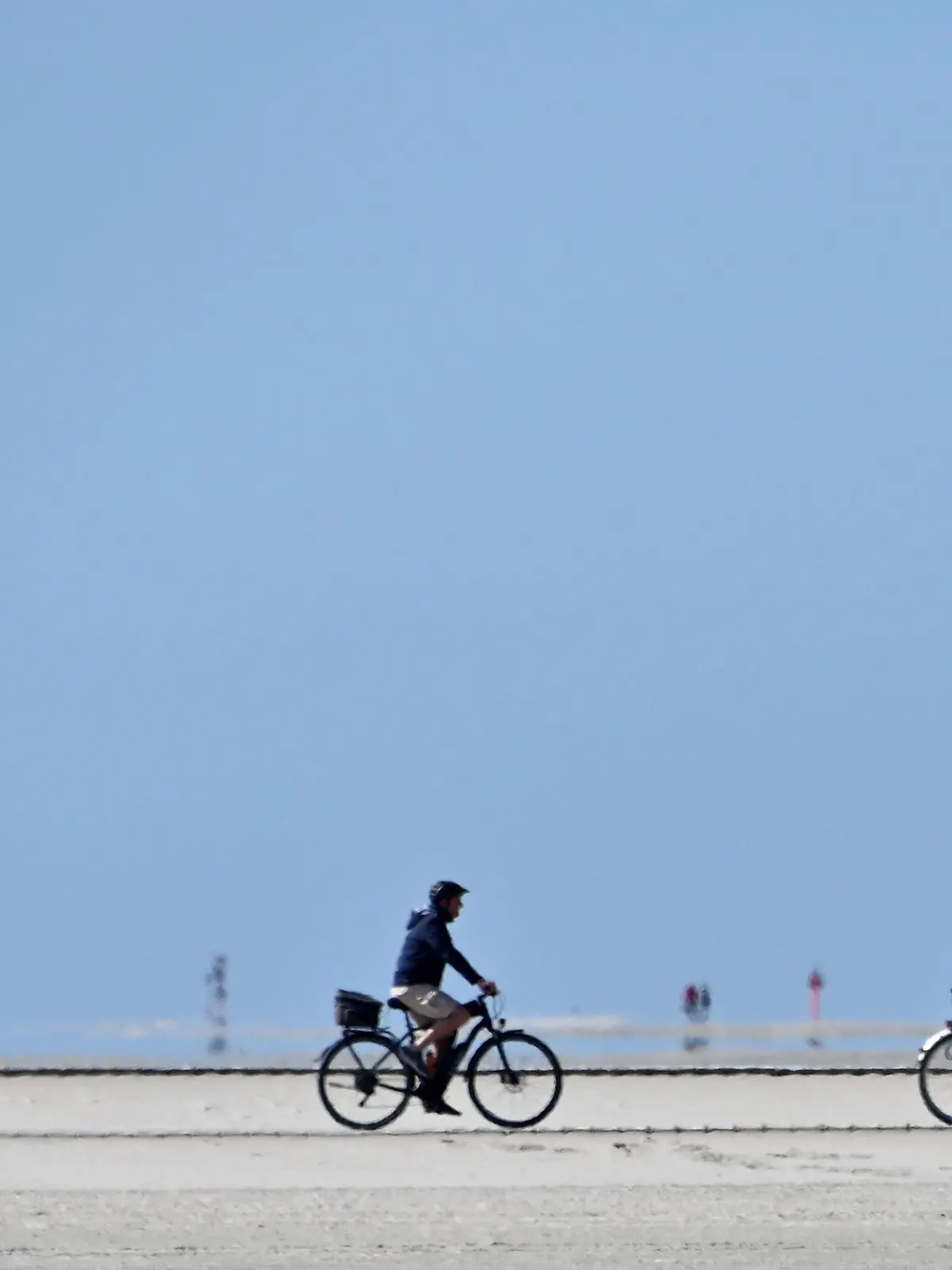 29.05.2020, Schleswig-Holstein, St.Peter-Ording: Radfahrer fahren bei blauem Himmel über den Nordseestrand. Für die nordfriesischen Inseln und Halligen der Nordsee sowie für St. Peter-Ording gilt über Pfingsten vom 30. Mai 6 Uhr bis 1. Juni 20 Uhr ein Betretungsverbot für Tagesgäste. Foto: Carsten Rehder/dpa +++ dpa-Bildfunk +++