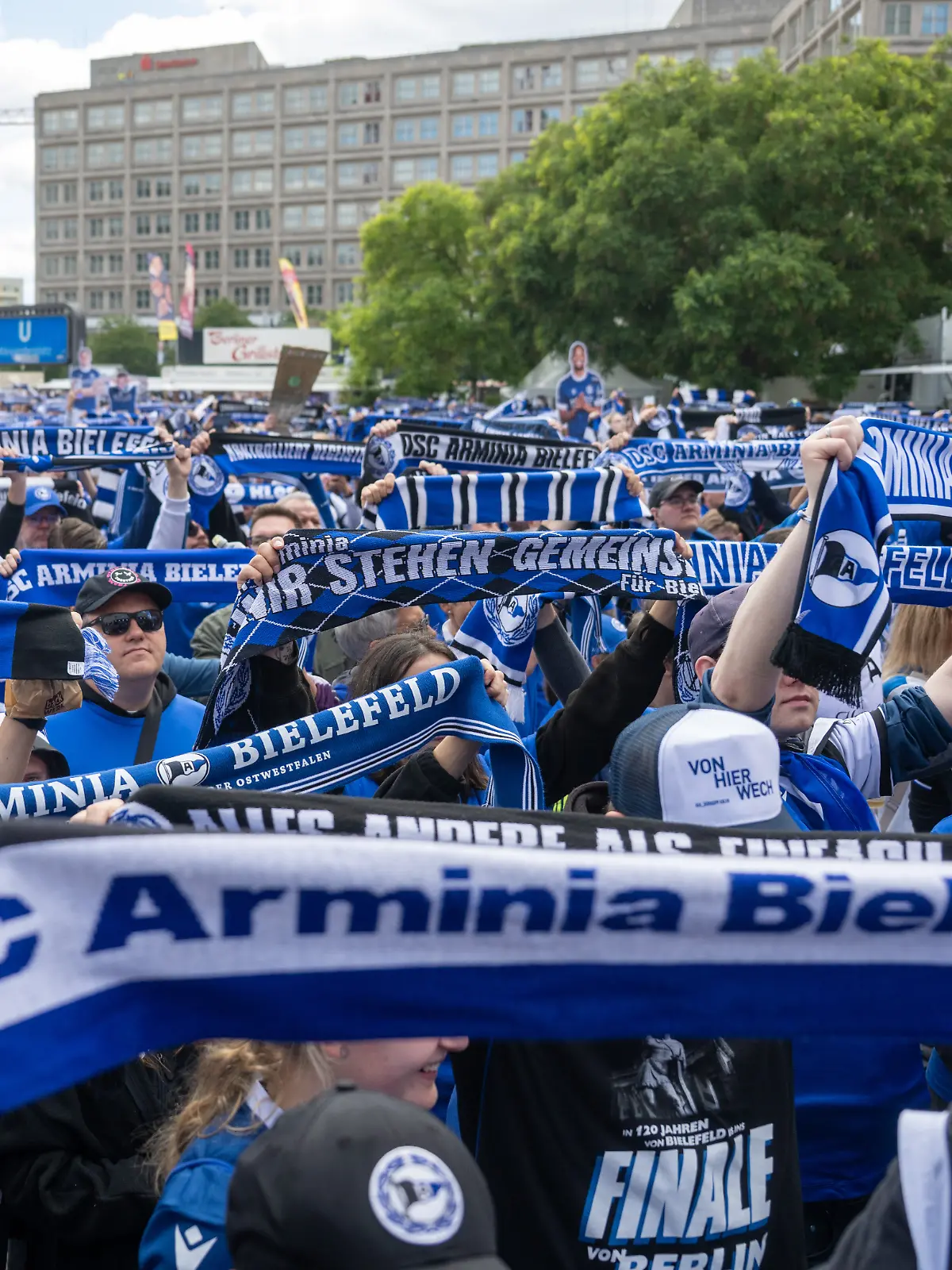 Bielefeld Fans stehen beim Fanfest auf dem Alexanderplatz und halten ihre Fanschals hoch.