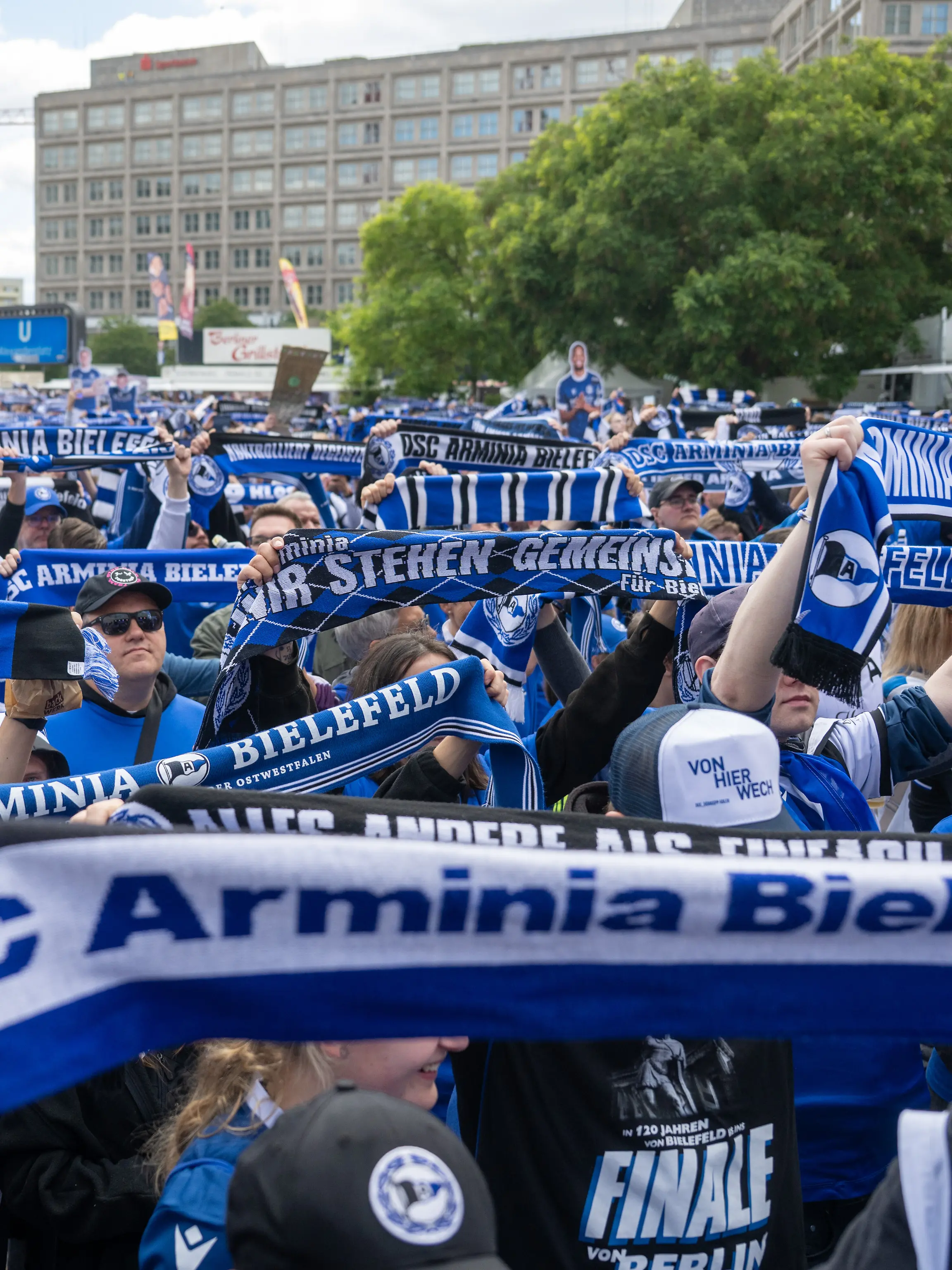 Bielefeld Fans stehen beim Fanfest auf dem Alexanderplatz und halten ihre Fanschals hoch.