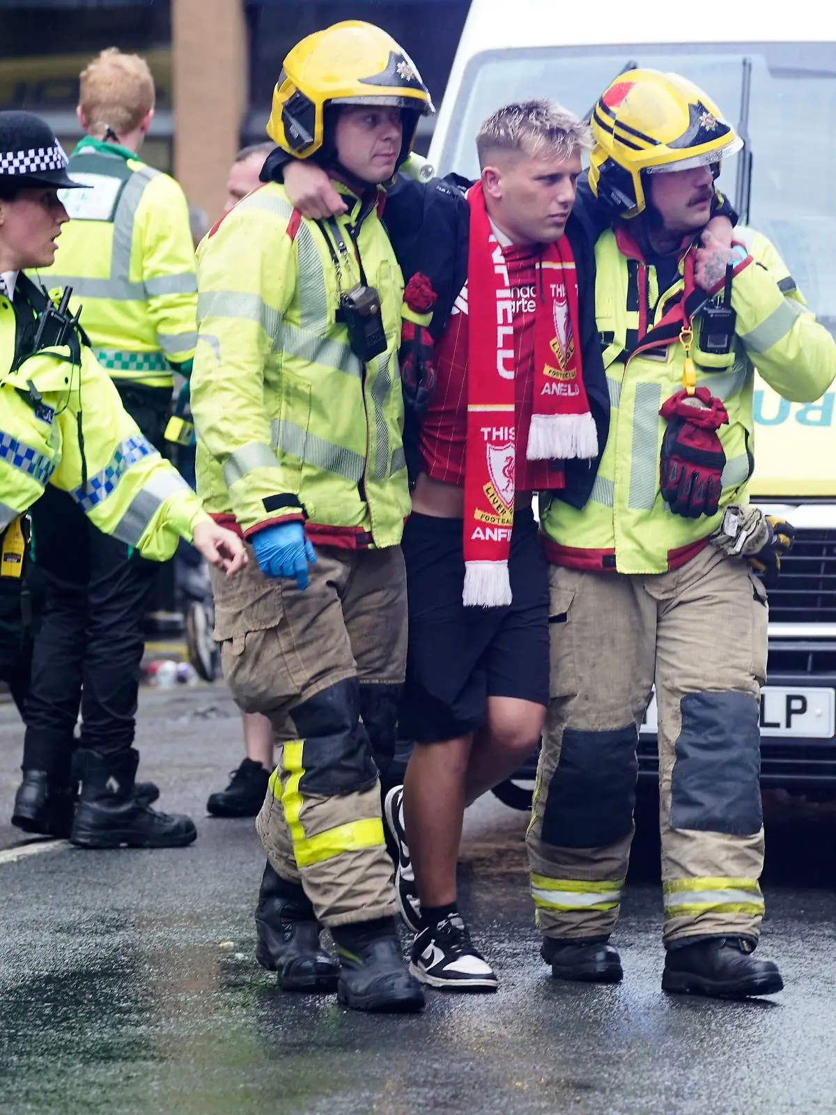 Rettungskräfte stützen einen offenbar verletzten Liverpool-Fan.