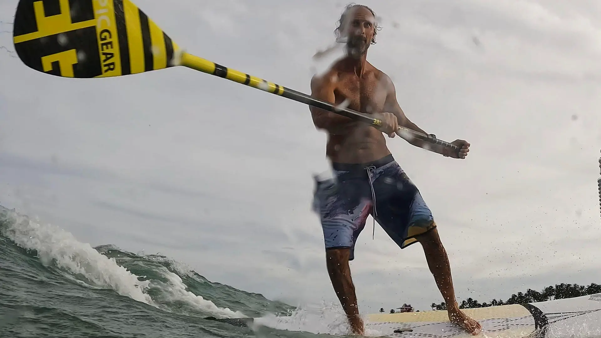 Graziano La Grasta, a local contractor and standup paddle board enthusiast, rides a small wave off South Beach, Friday, July 28, 2023, in Miami Beach, Fla. Humans naturally look to water for a chance to refresh, but when water temperatures get too high, some of the appeal is lost. (AP Photo/Rebecca Blackwell)