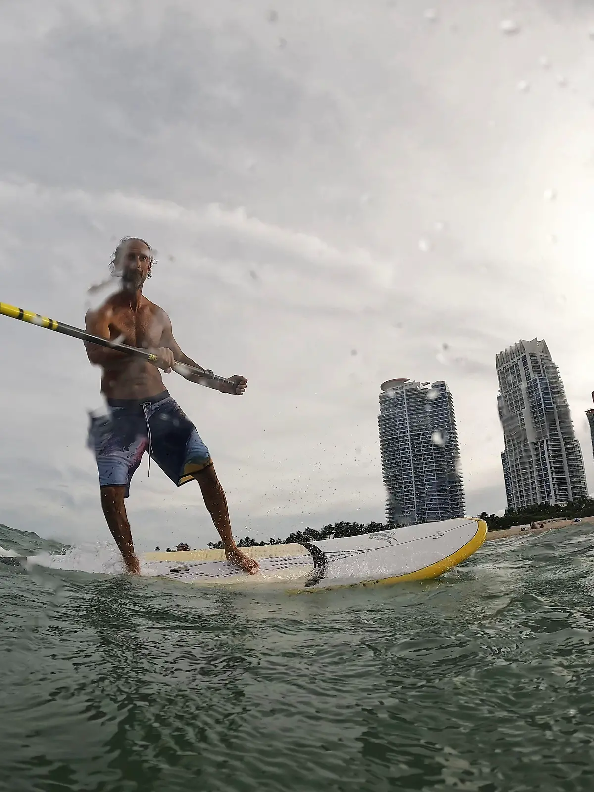 Graziano La Grasta, a local contractor and standup paddle board enthusiast, rides a small wave off South Beach, Friday, July 28, 2023, in Miami Beach, Fla. Humans naturally look to water for a chance to refresh, but when water temperatures get too high, some of the appeal is lost. (AP Photo/Rebecca Blackwell)