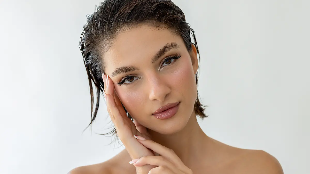 Eine junge Frau mit Make-up schaut in die Kamera.