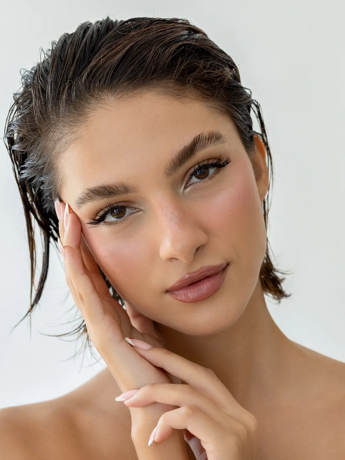 Eine junge Frau mit Make-up schaut in die Kamera.