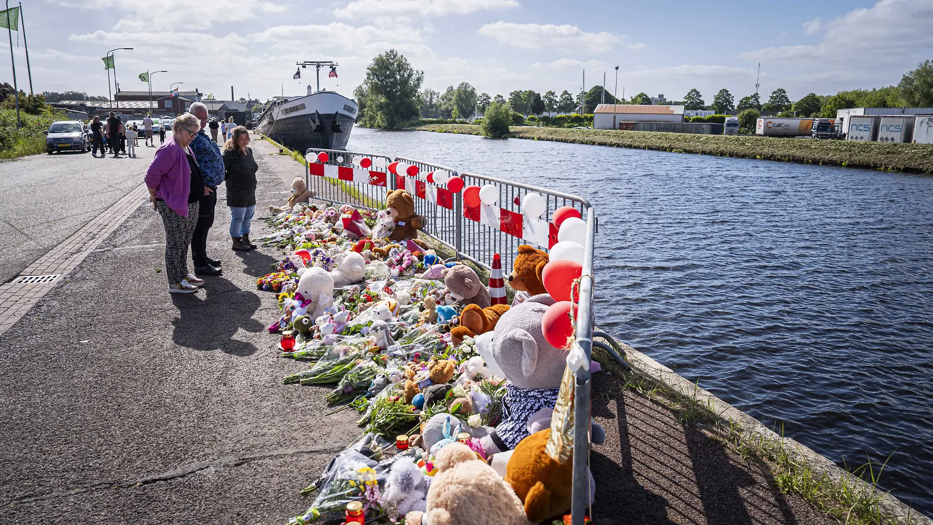 dpatopbilder - 21.05.2025, Niederlande, Winschoten: Menschen stehen an einer Gedenkstätte vor Blumen und Stofftieren. Nach tagelanger Suche gibt es Gewissheit: Die beiden im Nordosten der Niederlande vermissten Kinder sind tot. Jeffrey und seine Schwester Emma wurden im Auto ihres Vaters in einem Kanal gefunden. Foto: Jaspar Moulijn/ANP/dpa +++ dpa-Bildfunk +++