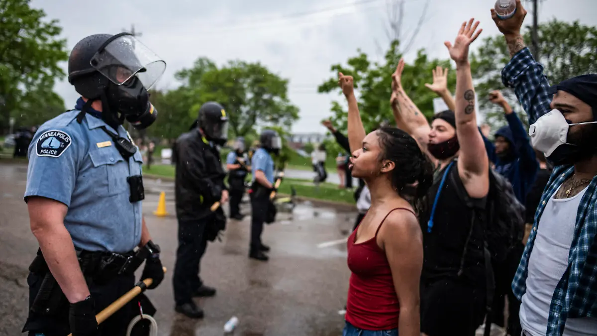 dpatopbilder - 26.05.2020, USA, Minneapolis: Demonstranten und Polizisten stehen sich während eines Protests für einen Mann afroamerikanischer Abstammung demonstrierten, der nach der Festnahme durch die Polizei verstarb, gegenüber. Der weiße Polizist kniete auf dem Hals des Mannes, welcher mehrmals darauf aufmerksam machte, dass er nicht atmen könne. Der Mann starb später im Krankenhaus. Foto: Richard Tsong-Taatarii/Star Tribune/AP/dpa +++ dpa-Bildfunk +++