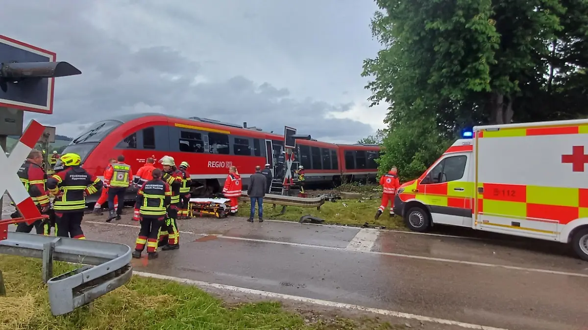 Rettungskräfte arbeiten an der Unfallstelle. bei einem Zusammenstoß von einem Zug und einem Lastwagen sind mehrere Menschen verletzt worden.