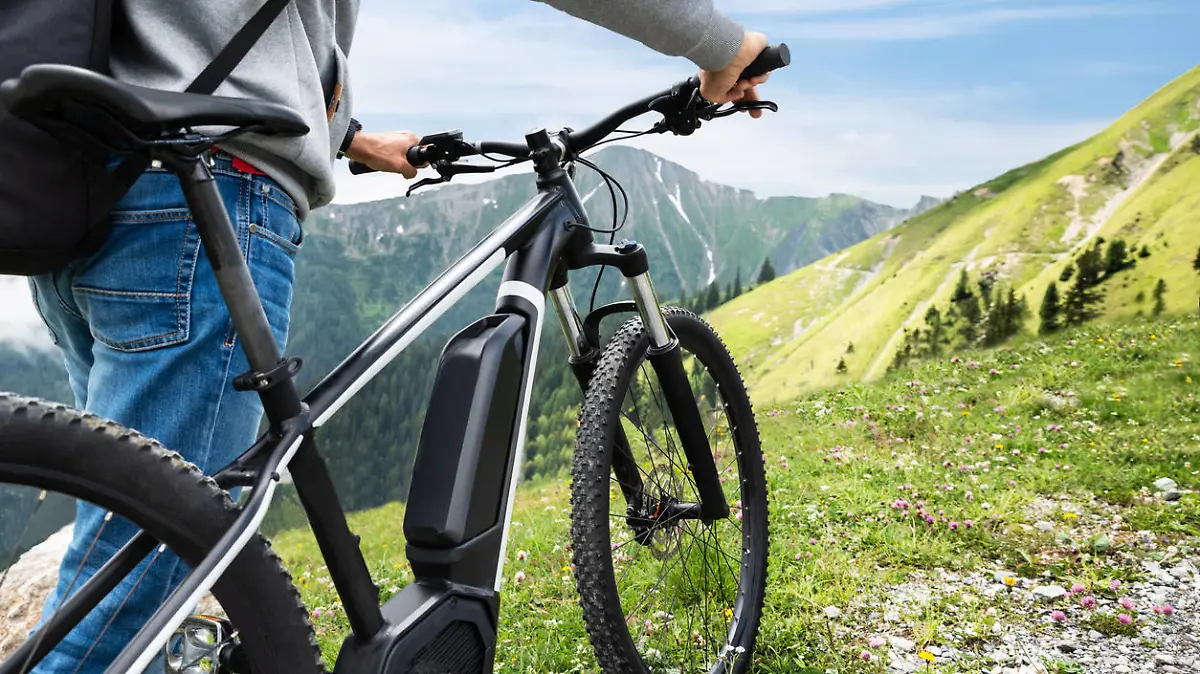 Mann schiebt E-Bike