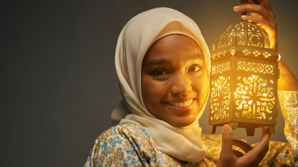 malay hijab with traditional clothing holding arabic lantern celebrating ramadan
