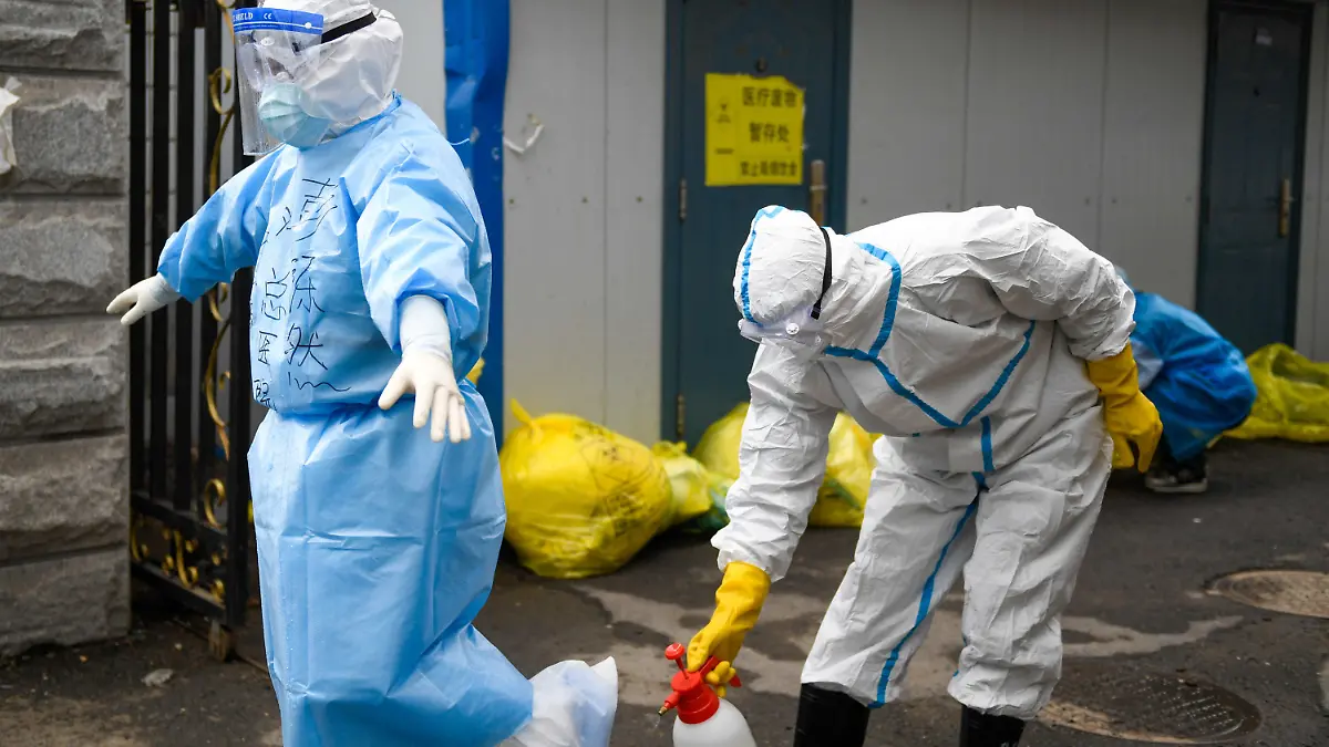 17.05.2020, China, Jilin: Ein medizinischer Mitarbeiter desinfiziert einen anderen, der kommt, um die COVID-19-Proben für einen Nukleinsäuretest im Zentrum für Krankheitskontrolle und Prävention einzureichen. Foto: Yan Linyun/XinHua/dpa +++ dpa-Bildfunk +++