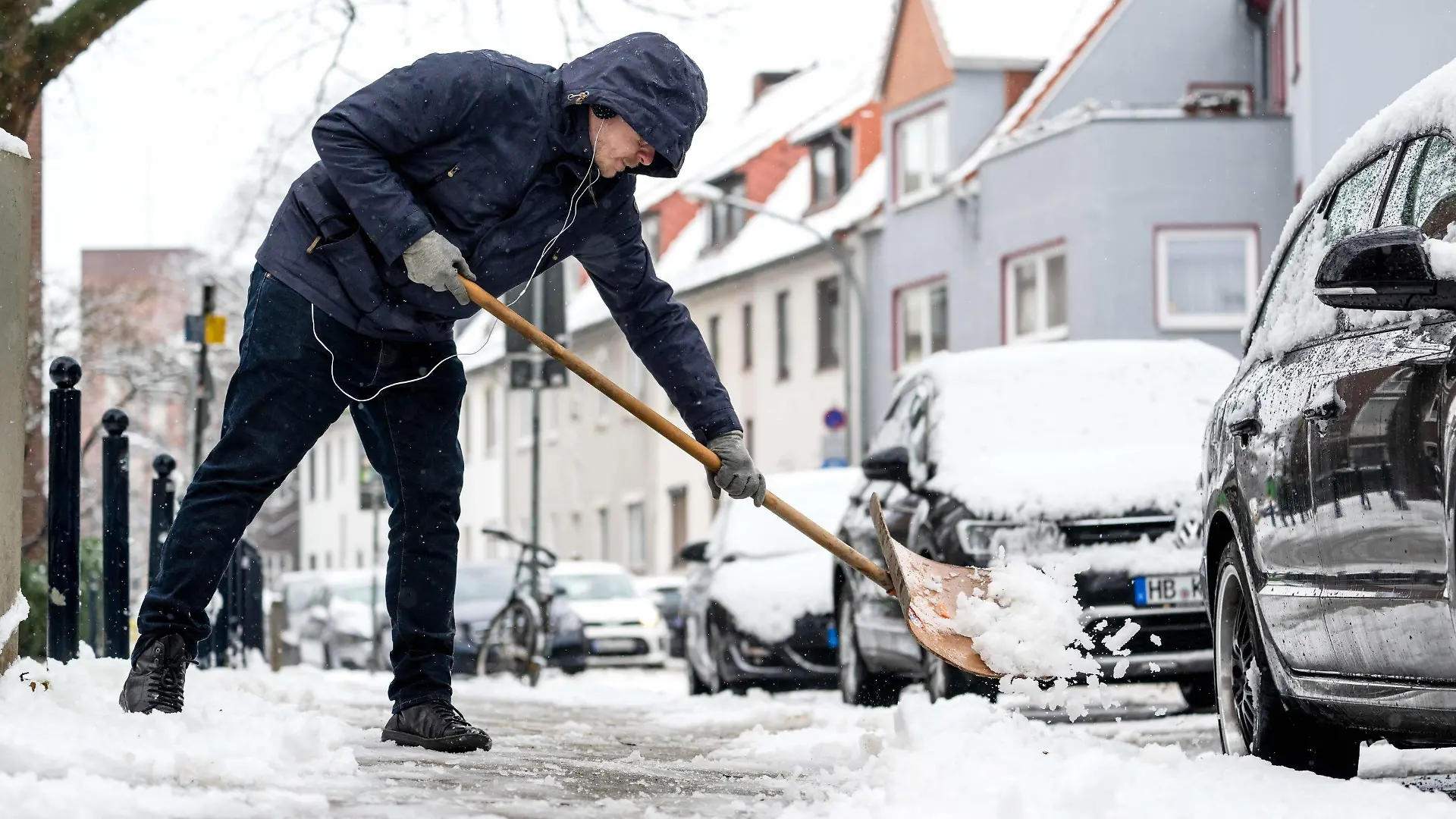 10.03.2023, Bremen: Ein Anwohner befreit den Fußgängerweg von Schnee. Das Wetter bleibt in den kommenden Tagen durchwachsen, jedoch sollen die Temperaturen steigen. Foto: Sina Schuldt/dpa +++ dpa-Bildfunk +++