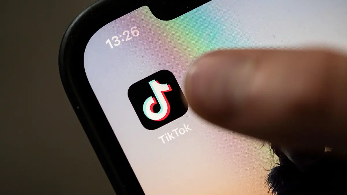 ARCHIV - 11.07.2022, Baden-Württemberg, Stuttgart: Ein Teenager tippt auf das Icon TikTok-App auf einem Smartphone. Die italienische Wettbewerbsbehörde hat eine Untersuchung gegen die Videoplattform Tiktok wegen einer als gefährlich eingestuften «Challenge» aufgenommen. Die aktuell populäre Mutprobe sei als «Französische Narbe» bekannt.(zu dpa: "Italien: Untersuchung gegen Tiktok wegen gefährlicher «Challenge»") Foto: Marijan Murat/dpa +++ dpa-Bildfunk +++