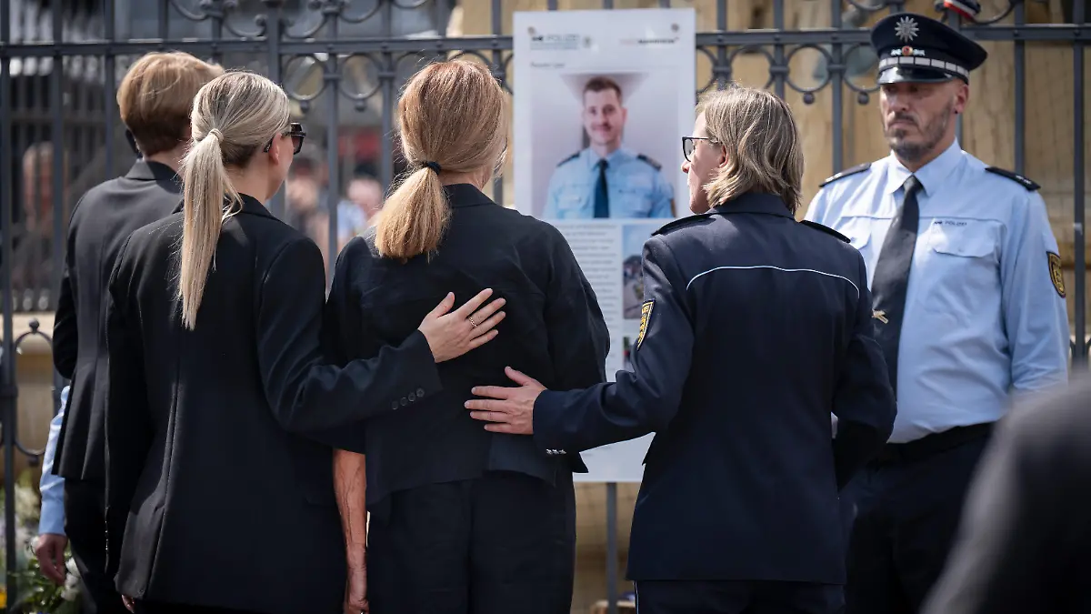 Vor einem Jahr, am 31.05.2024, wurde der 29-jaehrige Polizeihauptkommissar Rouven Laur auf dem Mannheimer Marktplatz Opfer eines Messerangriffs. Zwei Tage spaeter erlag er seinen schweren Verletzungen. Am Samstag (31.05.2025) erinnerte die Stadt Mannheim mit einer oeffentlichen Gedenkveranstaltung an Rouven Laur (Foto). Gemeinsam mit Vertretern von Politik, Polizei, Kirchen und Gesellschaft will sie ein Zeichen fuer Frieden, Respekt und Zusammenhalt setzen. (Foto re. die Mannheimer Polizeipraesidentin, Ulrike Schaefer (Schäfer) neben Mitgliedern der Familie Laur) Zum Gedenken an Rouven Laur wurde bei der Gedenkfeier eine Bodenplatte mit drei Edelsteinsternen der Oeffentlichkeit uebergeben. (Siehe epd-Meldung vom 31.05.2025)