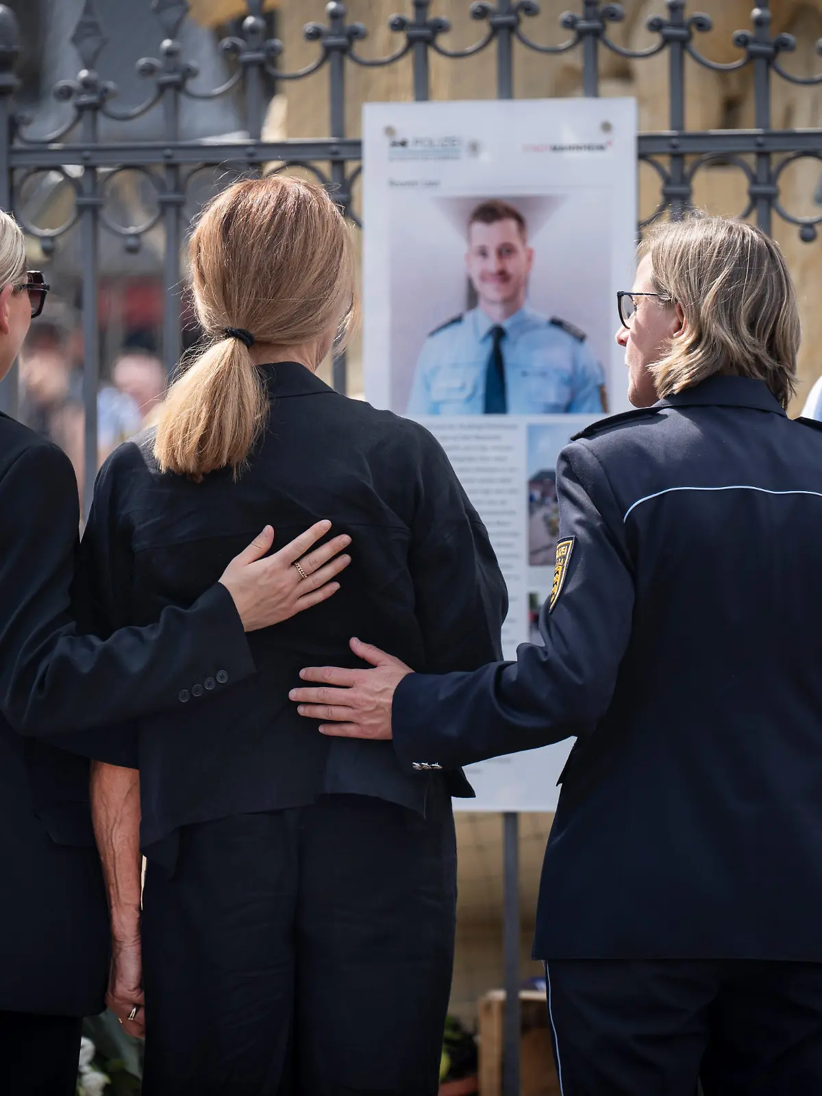 Vor einem Jahr, am 31.05.2024, wurde der 29-jaehrige Polizeihauptkommissar Rouven Laur auf dem Mannheimer Marktplatz Opfer eines Messerangriffs. Zwei Tage spaeter erlag er seinen schweren Verletzungen. Am Samstag (31.05.2025) erinnerte die Stadt Mannheim mit einer oeffentlichen Gedenkveranstaltung an Rouven Laur (Foto). Gemeinsam mit Vertretern von Politik, Polizei, Kirchen und Gesellschaft will sie ein Zeichen fuer Frieden, Respekt und Zusammenhalt setzen. (Foto re. die Mannheimer Polizeipraesidentin, Ulrike Schaefer (Schäfer) neben Mitgliedern der Familie Laur) Zum Gedenken an Rouven Laur wurde bei der Gedenkfeier eine Bodenplatte mit drei Edelsteinsternen der Oeffentlichkeit uebergeben. (Siehe epd-Meldung vom 31.05.2025)