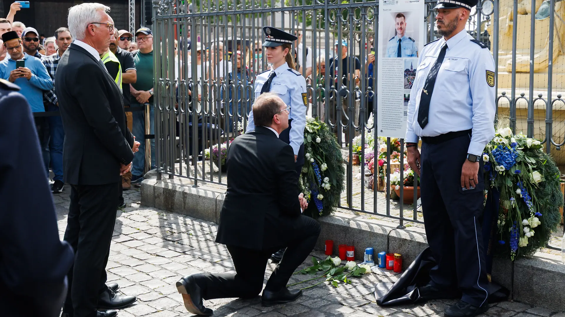 dpatopbilder - 31.05.2025, Baden-Württemberg, Mannheim: Alexander Dobrindt (CSU), Bundesinnenminister, kniet vor der Gedenktafel für Rouven Laur. Links steht Thomas Strobl (CDU), Innenminister von Baden-Württemberg. Anlässlich des ersten Jahrestags des tödlichen Angriffs auf Polizeihauptkommissar Rouven Laur, erinnert die Stadt Mannheim mit einer öffentlichen Gedenkveranstaltung an ihn. Foto: Lando Hass/dpa +++ dpa-Bildfunk +++ Marktplatz.
