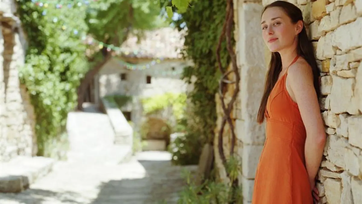 Frau in orangenem Sommerkleid.