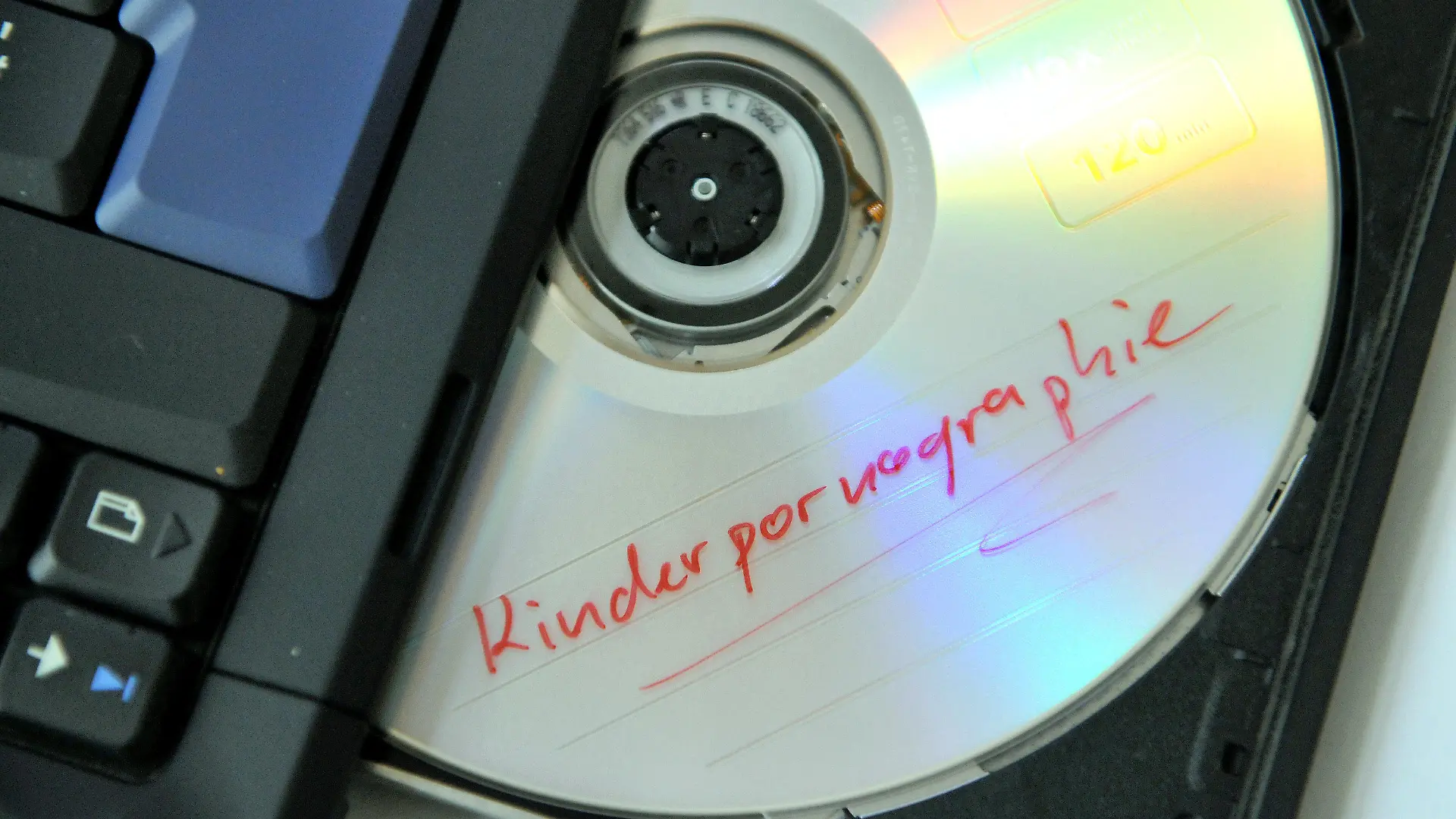 ARCHIV - Illustration - Eine DVD mit der Aufschrift «Kinderpornographie» liegt am 23.01.2009 in Kassel im Laufwerk eines Notebooks. Den USA ist es in Zusammenarbeit mit ausländischen Behörden gelungen, einen internationalen Kinderpornografie-Ring auszuheben. 52 der 72 Angeklagten wurden der Mitteilung zufolge inzwischen in den USA und in Übersee festgenommen, vier bereits zu Gefängnisstrafen zwischen 20 und 30 Jahren verurteilt. Im Ausland seien mehr als 500 Menschen ins Visier genommen worden. Foto: Uwe Zucchi dpa (Zu dpa 0662 vom 04.08.2011) +++(c) dpa - Bildfunk+++