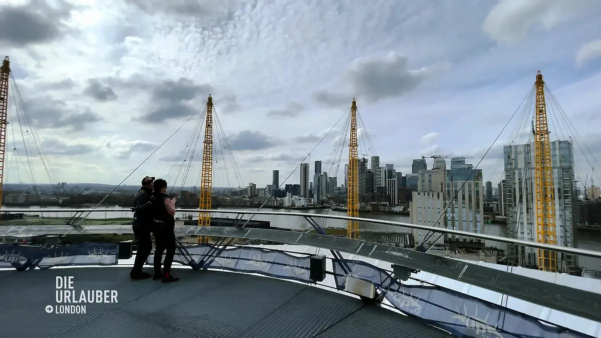 Die Luxus-Urlauber*innen blicken über die Skyline Über den Dächern Londons